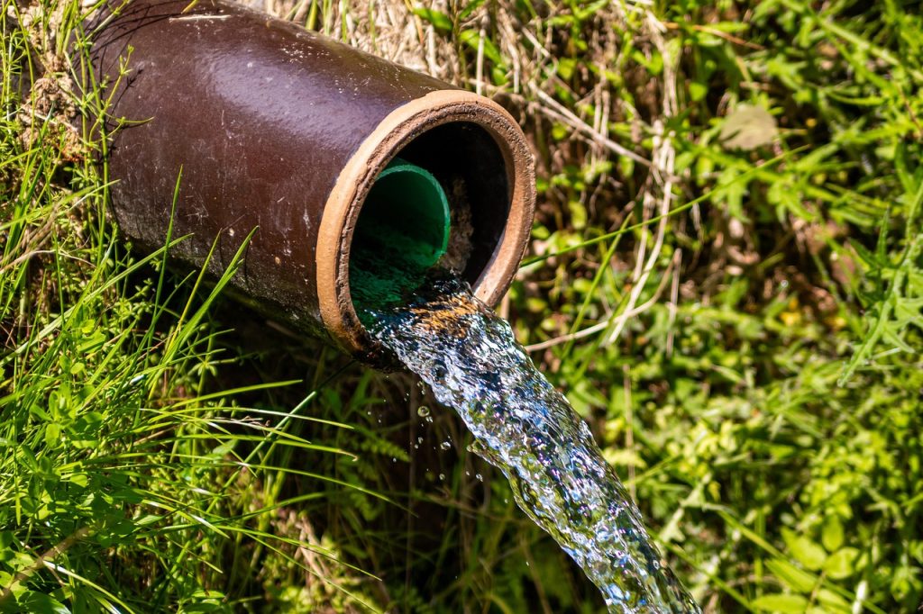 water flowing from relined outdoor drainage pipe